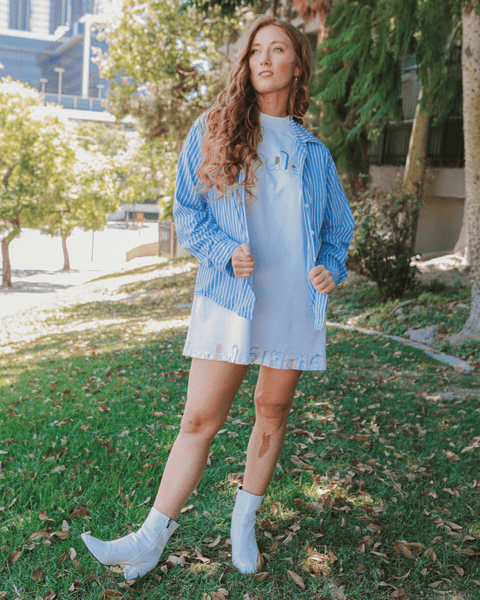 A red-haired model styling the wonder thread oversized tee with urban outfitters orange cargo pants and a leather jacket and boots.