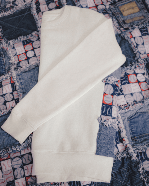 A vintage baseball jean quilt with the bubuleh fenway crewneck on top with the seams up showing baseballs and old jean pockets.