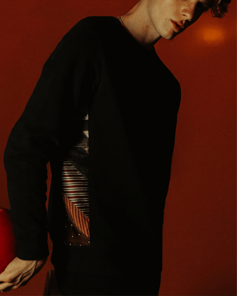A boy bowling with a black bubuleh sweater on