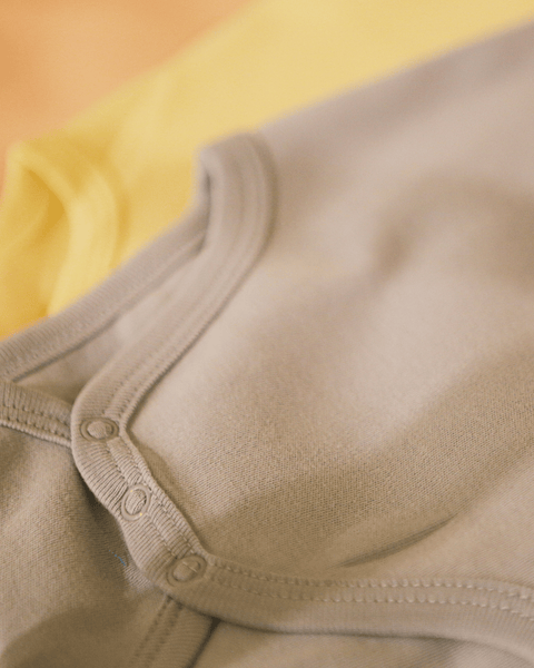 Two closeup shots showing the bottom snaps for the bubuleh baby onesies.