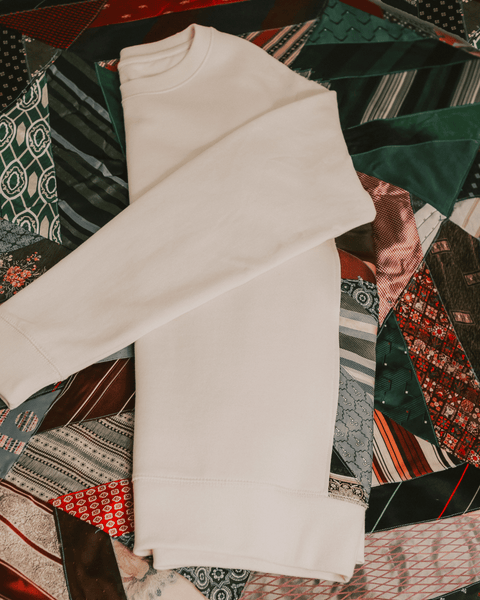 A closeup photo of red and green retro ties and a natural white sweater.