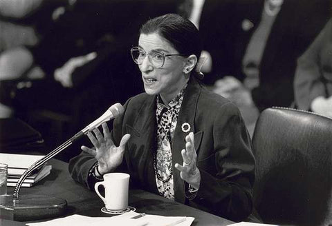 A photo of Ruther Bader Ginsburg being sworn in as a Supreme Court Justice in black and white.