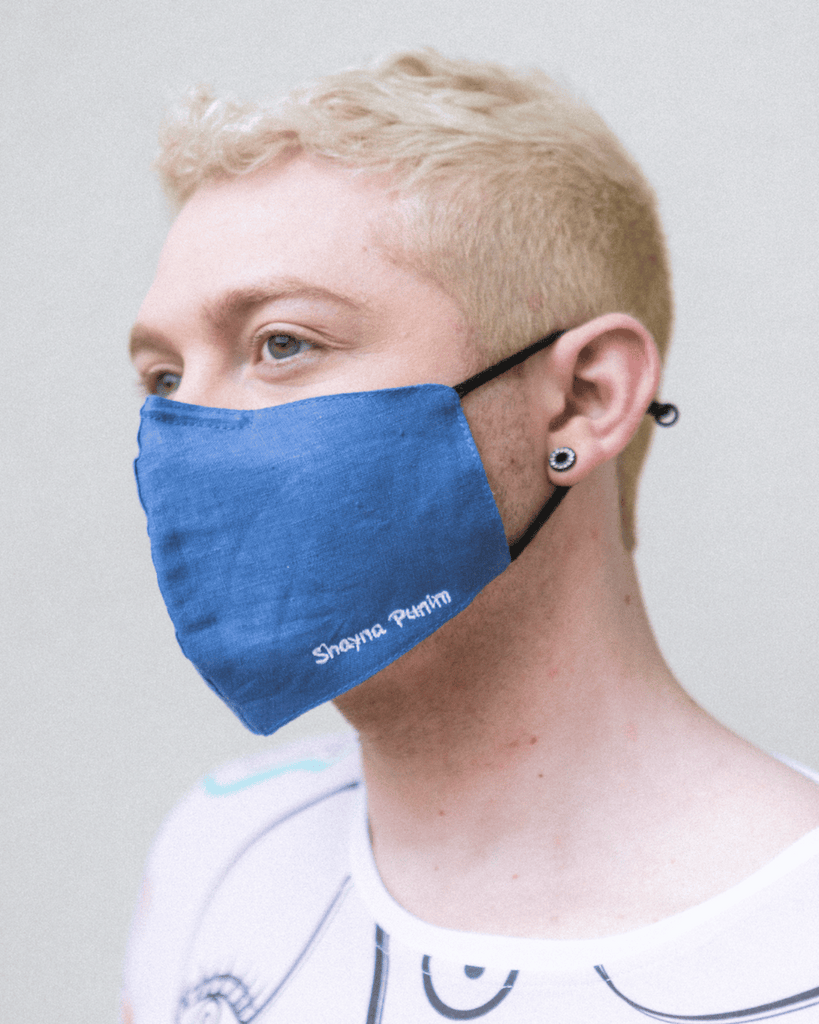 A denim face mask that says "shayna Punim" embroidered on the front left.