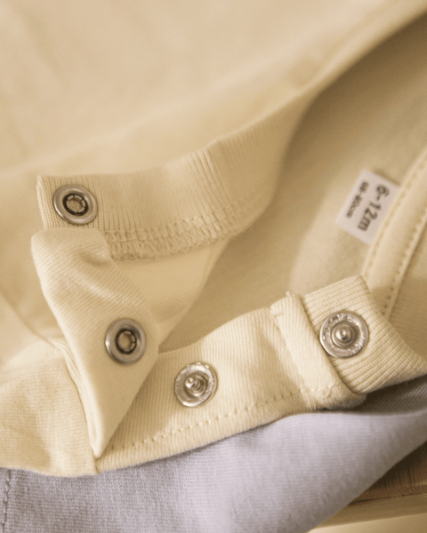 Yellow buttons on a baby onesie