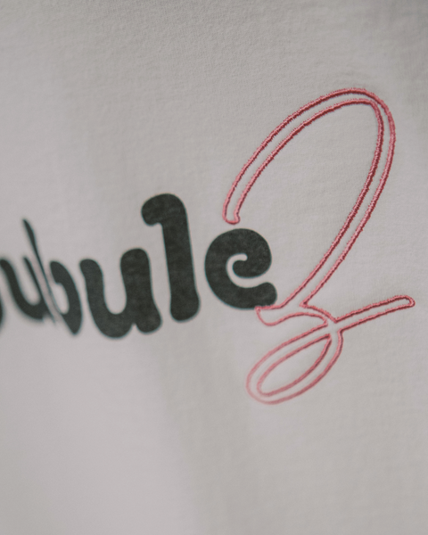 A closeup photo on a white muscle tee showing an embroidery pink "z" that spells out bubulez. It's a play on the word lesbian for Pride month.