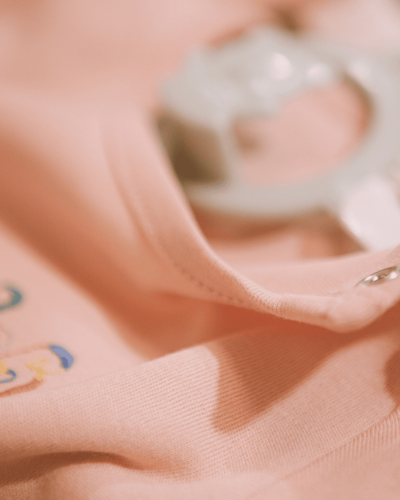 A closeup shot showing the metal snap buttons on the shoulders of the bubuleh onesies for babies.