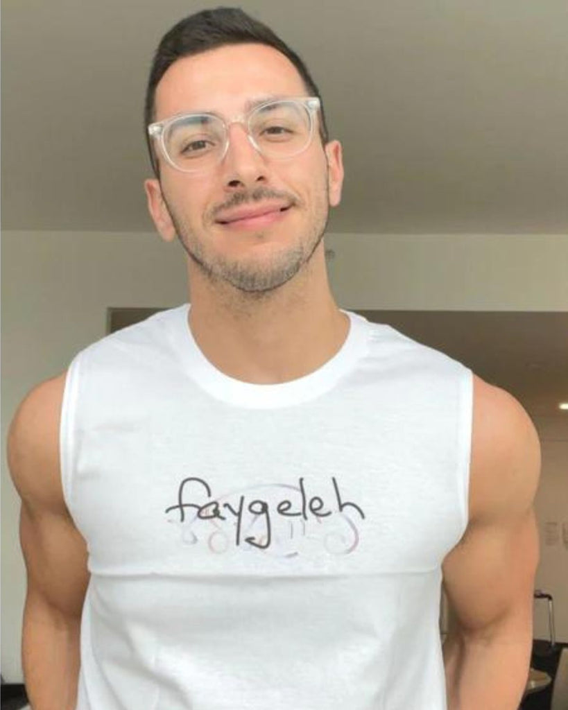A photo of New York City influencer and chef Jake Cohen wearing a white tank top that reads "faygeleh".