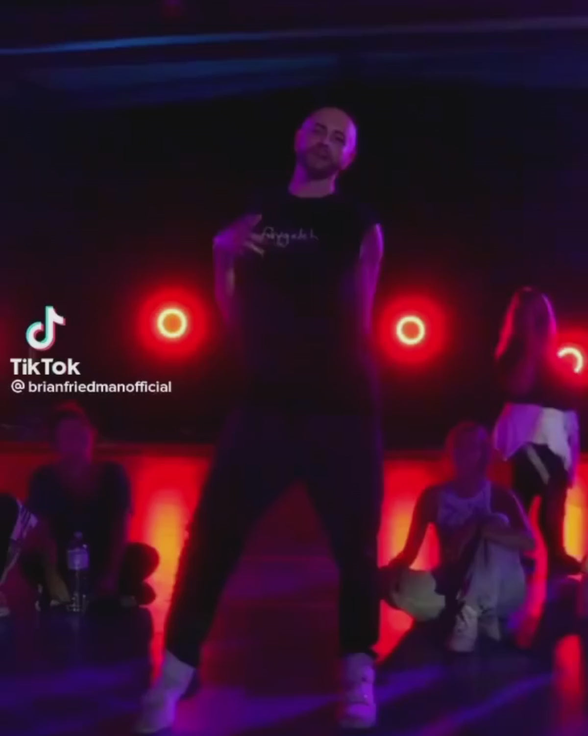 A video of celebrity choreographer Brian Friedman dancing in bubuleh's white faygeleh tank top and kiss my tuchus shorts, with black heels to Beyoncé in a dance class.