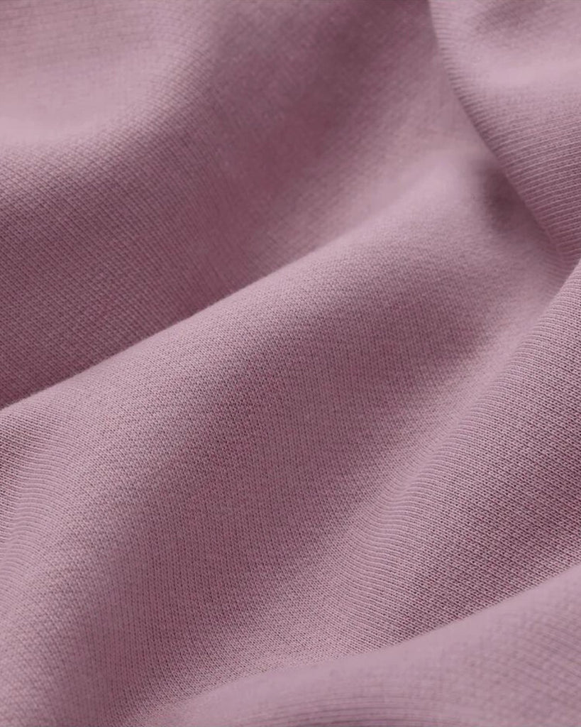 A closeup of lavender french terry organic cotton with waves to show the feel of the fabric.